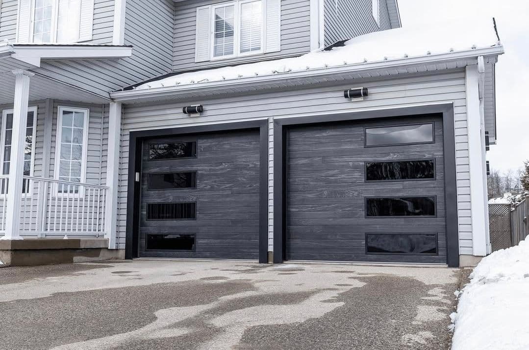 Modern gray garage doors with horizontal windows on a stylish residential home.